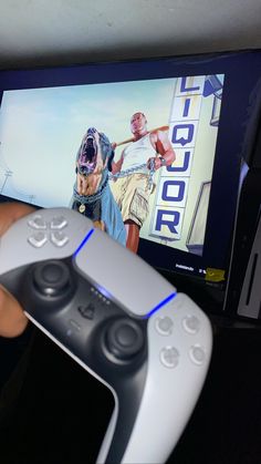 a person holding a video game controller in front of a tv with an image on it