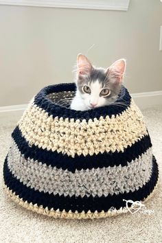 a cat sitting in a crocheted basket on the floor