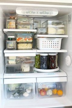 an open refrigerator filled with lots of food and storage containers on top of the shelves