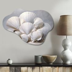 there is a wall decoration with seashells on it and a lamp next to it