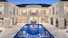 a large house with a swimming pool in the middle of it and lots of windows