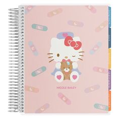 a pink notebook with an image of a hello kitty holding a teddy bear on it