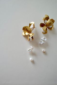 ⭐️⭐️⭐️⭐️⭐️ "I absolutely adore these gold pearl drop earrings! They are the perfect blend of elegance and simplicity, and they add a touch of sophistication to any outfit. The pearls have a beautiful luster and the gold setting is just stunning. I wore them to a wedding and received so many compliments. They are lightweight and comfortable to wear all day. I couldn't be happier with my purchase! Highly recommend!" - Olivia M. Bridal Jewelry Earrings, Gold High Jewelry, Floral Pearl Earrings, Pearl Earing Ideas, Elegant Bridal Dangle Earrings With Flower Charm, Elegant Bridal Earrings With Handmade Gold Flowers, Elegant Handmade Flower Drop Bridal Earrings, Elegant Gold Bridal Earrings With Handmade Flowers, Elegant Handmade Flower Bridal Drop Earrings