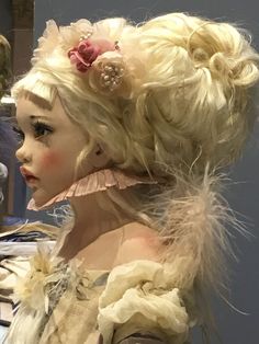 a mannequin with blonde hair and flowers in her hair