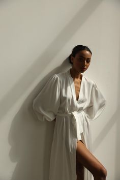 Our long bridal silk robe with wide long sleeves. It could be made of satin or pure mulberry silk. The robe is both casual and elegant, you may wear it on the hen party or spontaneously around your home on a daily basis. It is also an amazing outfit for your vocation, to wear it on the beautiful beach or by the pool as a cover up. -Our model wears size XS, her measurements are 82/61/87 cm and she is 172 cm tall. -Attached with belt. -Arrives beautifully packaged in tissue paper with ribbon -Leng Kimonos, Silk Robe Outfit, White Kimono Outfit, Silk Bathrobe, Silk Bridal Robe, Bridal Dressing Gown, Satin Bridal Robe, Silk Robe Long, Kimono Gown