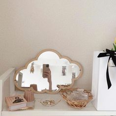 a white shelf topped with a mirror and jewelry