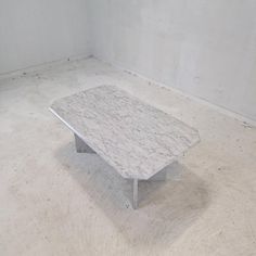 a white marble coffee table in an empty room