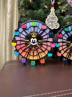 two stained glass fan shaped ornaments sitting on top of a table next to a christmas tree