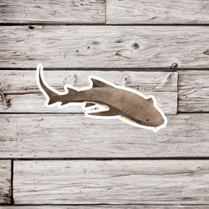 a sticker of a shark on a wooden background