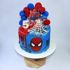 a spiderman themed birthday cake with balloons