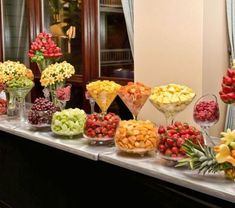 a buffet table filled with lots of different types of fruits and flowers on it's sides