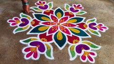 a person standing next to a colorful flower design on the ground