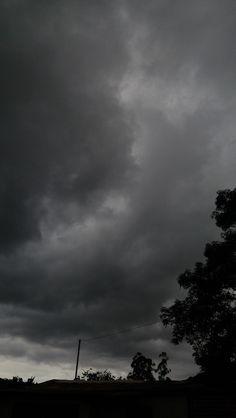 the sky is very dark and cloudy with some clouds in it's foreground