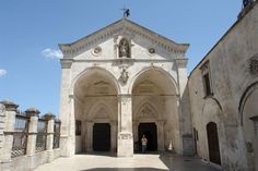 a person standing in the doorway of an old building with stone walls and arches on both sides