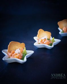 three small white bowls filled with food on top of a table