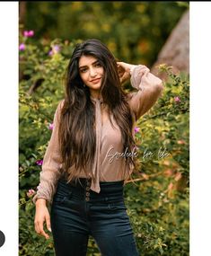 a beautiful young woman posing in front of flowers