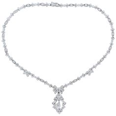 A feminine necklace made in Edwardian style featuring a 0.54 carat round cut diamond drop. The ribbons and bows of this platinum necklace are studded with 3.82 carats of round cut diamonds with a milgrain border. The detachable drop has a hook so that is may be worn as a pendant. The seamless finish provides a box clasp closure and safety latch. Necklace Length: 16.25 inches Necklace Width: 0.25 inches Drop Length: 1.50 inches Drop Width: 0.75 inches Elegant Platinum Diamond Necklace With Baguette Diamonds, Elegant Platinum Necklace With Baguette Diamonds, Elegant Formal Diamond Necklace With Baguette Diamonds, Victorian Pendant Necklace, Art Deco Pendant Necklace, Platinum Necklace, Playful Jewelry, Feminine Necklace, Victorian Pendants