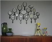 there are many spoons hanging on the wall next to a vase and other items