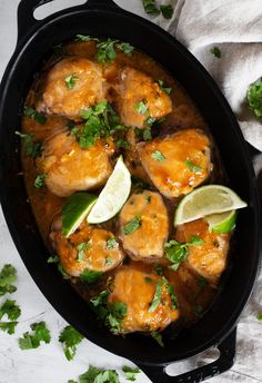 chicken with cilantro and lime in a black skillet on a white table