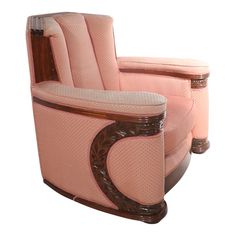 a pink recliner chair with wooden trimmings on the arms and back, sitting in front of a white background