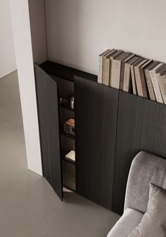 an open book shelf in the corner of a room next to a chair and bookshelf