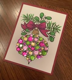 a card with a christmas ornament made out of buttons and bows on it