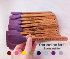 a hand is holding a set of 8 personalized wooden pencils