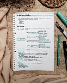 a notepad sitting on top of a table next to some pens