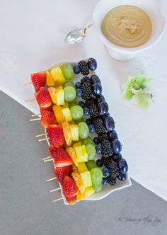 fruit skewers with peanut butter dip in the background