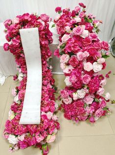 pink flowers are arranged in the shape of an i - letter and one is made out of white paper