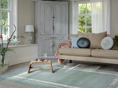 a living room filled with furniture and lots of window sill space next to a couch