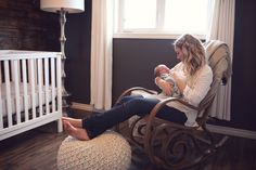 a woman is sitting in a rocking chair with her feet up and holding a baby