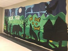 this is an image of a mural on the wall in a school hallway that says book fair wildernesss get lost in a book