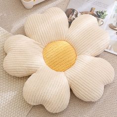 a white flower shaped pillow sitting on top of a table