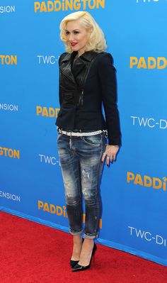 a woman standing on top of a red carpet next to a blue wall with the words paddington