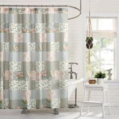 a shower curtain with flowers on it in a white room next to a bathtub