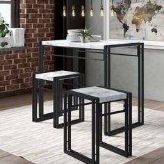 three black and white stools sitting in front of a kitchen counter with brick walls