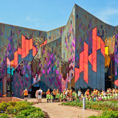 many people are standing in front of a colorful building