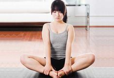 a woman sitting in the middle of a yoga pose