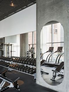 a gym with rows of exercise equipment and mirrors