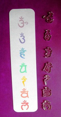 a white bookmark with the word buddha written in different languages and symbols on it