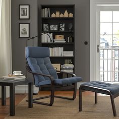 a living room with a chair and ottoman in front of a book shelf filled with books