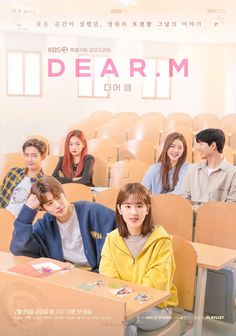 people sitting at desks in front of a sign that says dear m on it