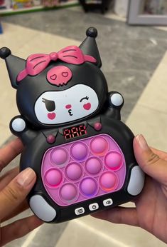 a person holding up a cell phone shaped like a cat