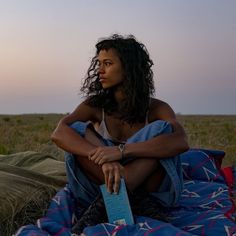 a woman sitting on top of a blue blanket