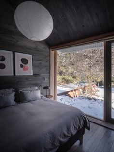 a bed sitting in a bedroom next to a sliding glass door with snow on the ground