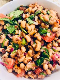 a white bowl filled with lots of food on top of a table