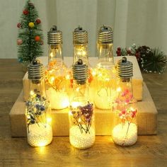 lighted mason jars with flowers in them sitting on a table