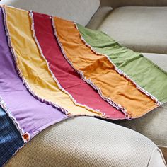 a multicolored blanket sitting on top of a couch