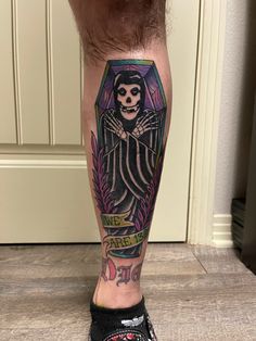 a man's leg with a tattoo on it that has a skeleton in the center